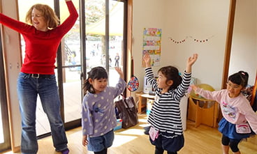 写真:外国人講師と遊ぶ子どもたち